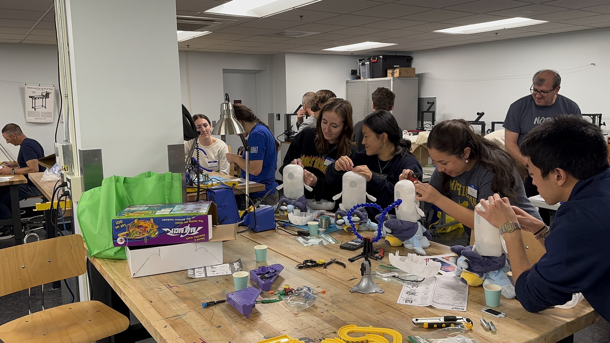 A group of young adult women work on modifying toys for children with disabilities